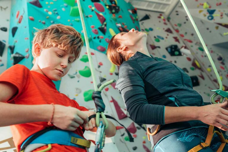 Mom and son getting ready for indoor rock climbing a metaphor to get ready for the teen years