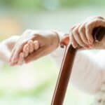family member holding old woman's hand to talk about death arrangements