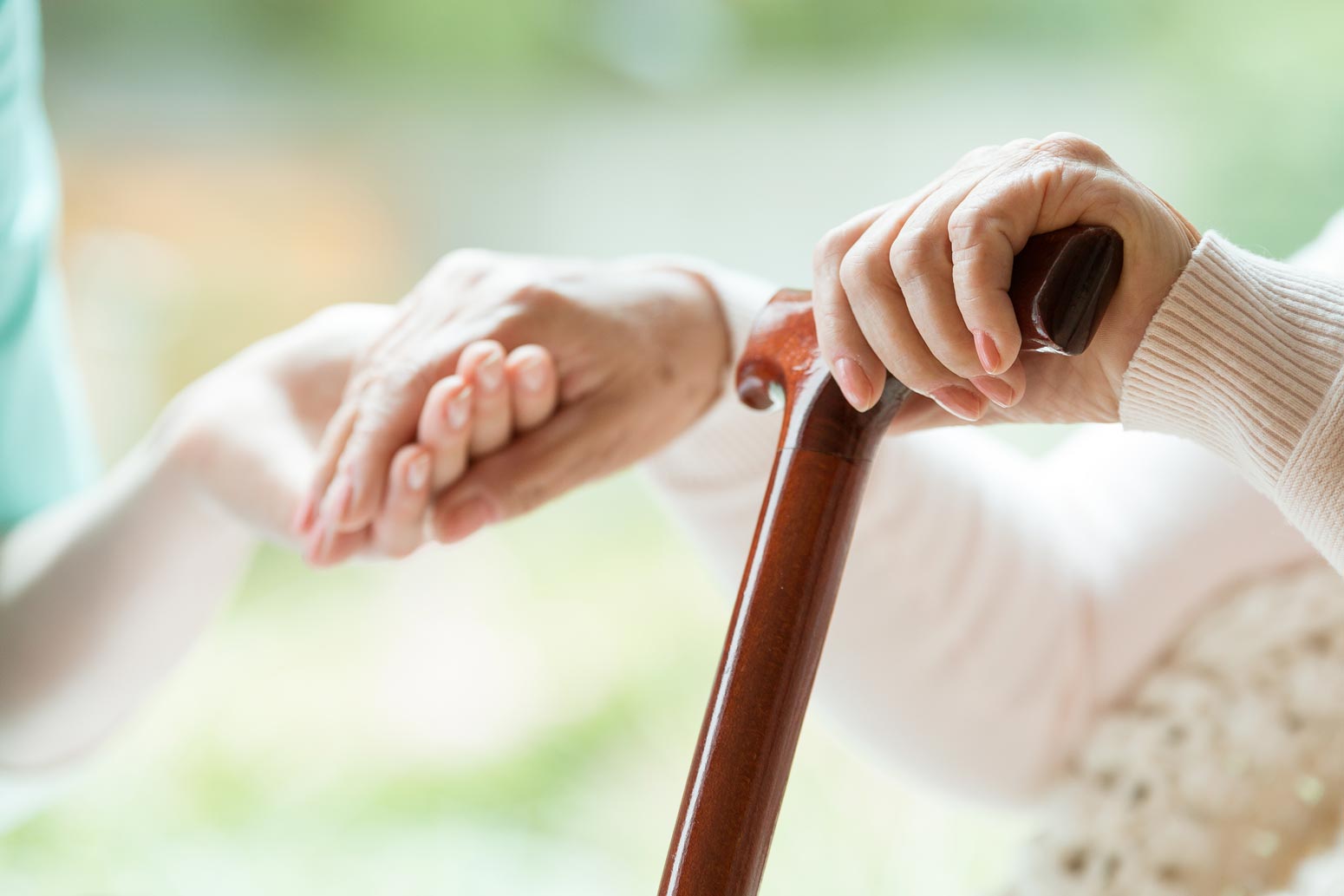 family member holding old woman's hand to talk about death arrangements