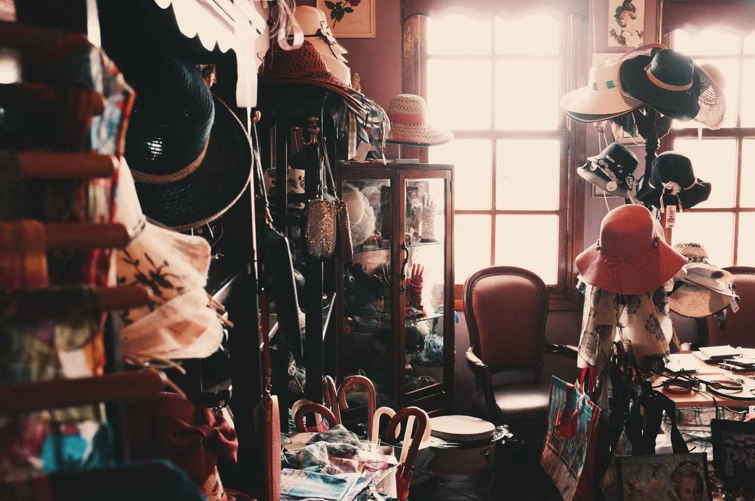 dimly lit room exhibiting a hoarding disorder with clothing and other accessories stacked on top of each other in abundance