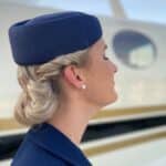 profile of female airline attendant standing next to a plane with eyes closed remembering September 11