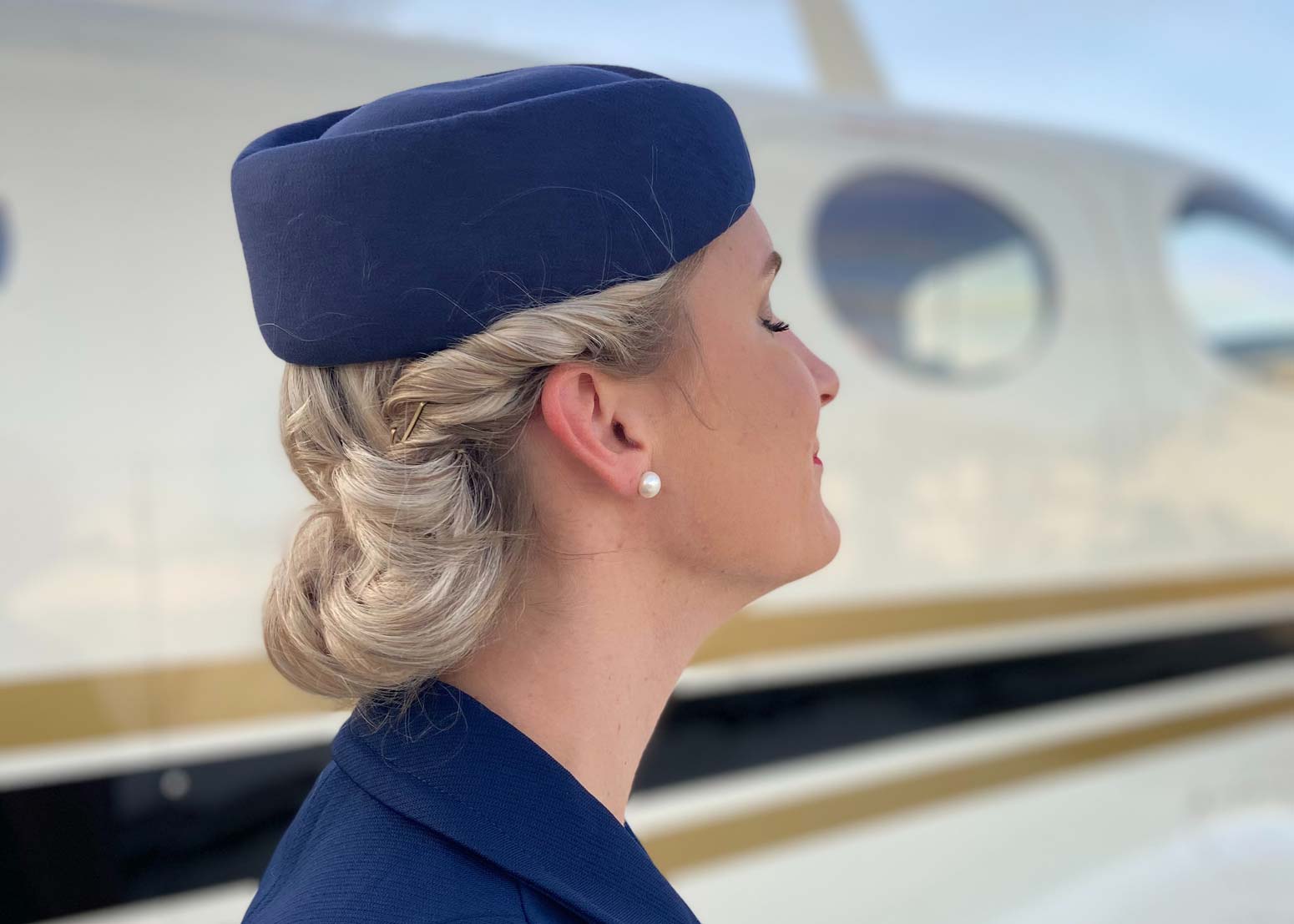 profile of female airline attendant standing next to a plane with eyes closed remembering September 11