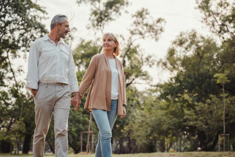 older couple walking outside hand in hand