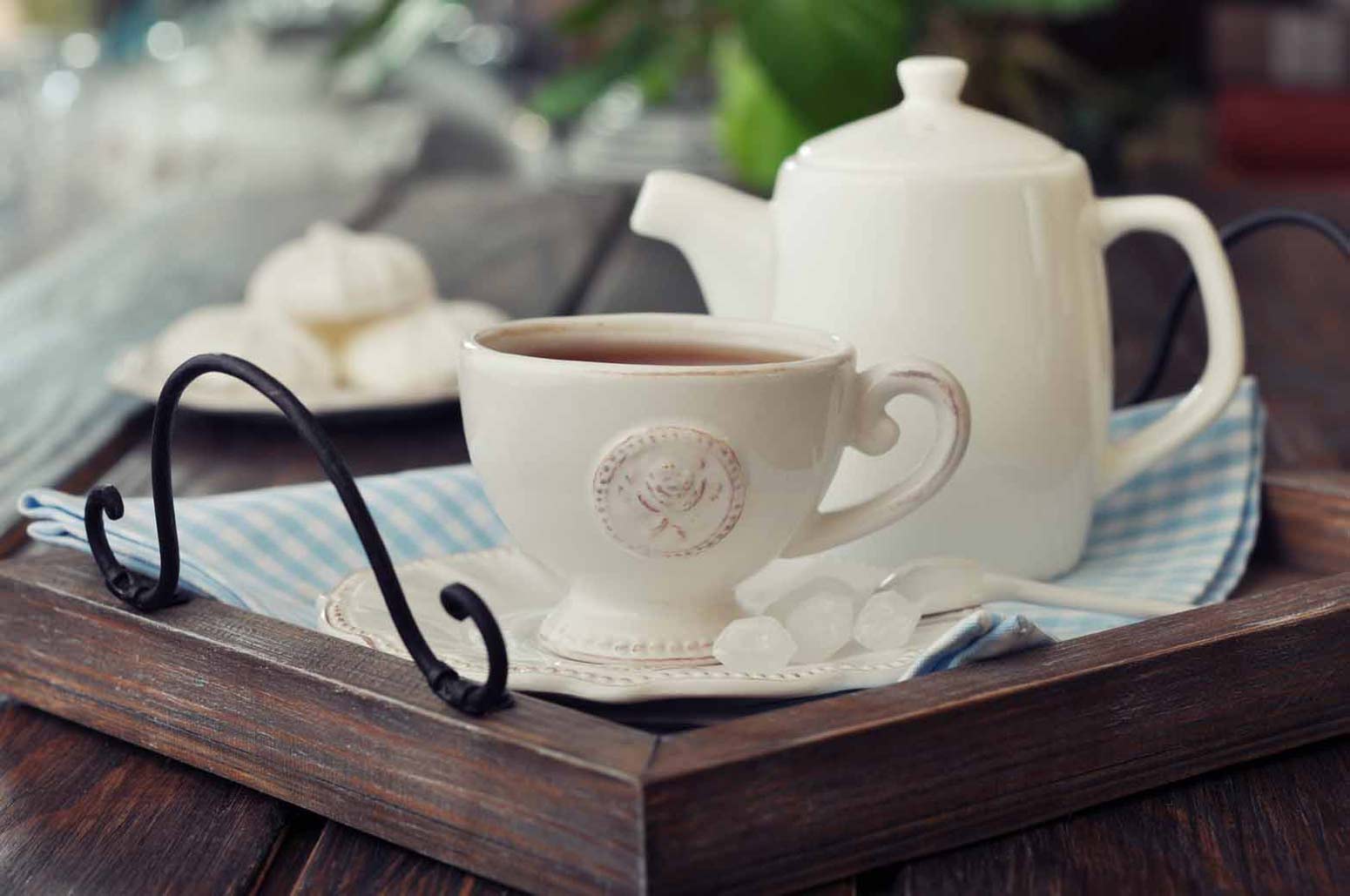 porcelain tea cup and tea pot on a wooden tray