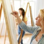 blond woman creating art on a canvas wondering if it's bad to be selfish
