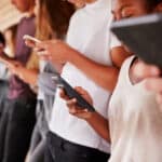 row of teens on their phones phubbing