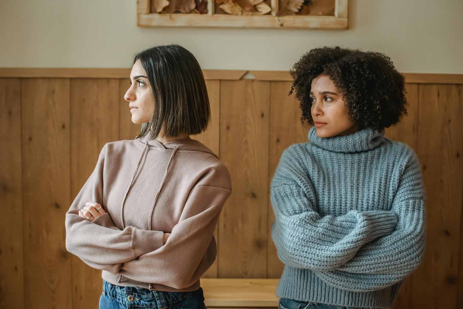 two women stand next to each other with arms crossed trying to figure out how to know when it's time for a friendship to end