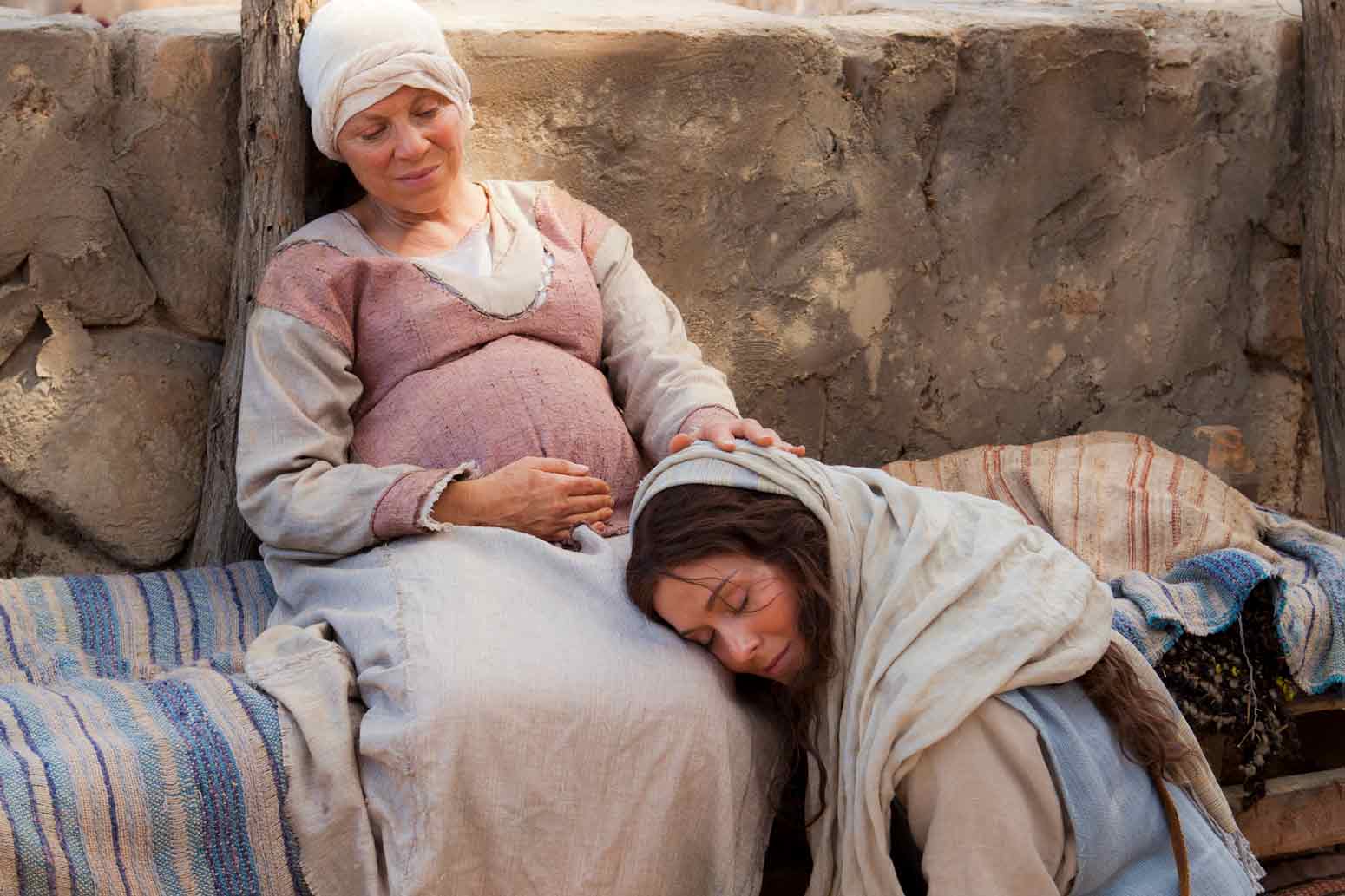 Mary laying her head on a pregnant Elizabeth's lap