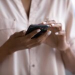 woman holding a smartphone, a visual reminder of controlling your screen time