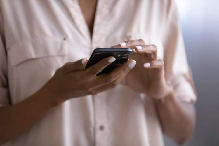 woman holding a smartphone, a visual reminder of controlling your screen time