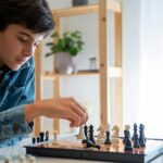 A young boy focused on a chess game, representing the importance of recognizing when to let your kids quit