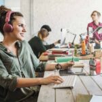 woman in an office smiles while working on a computer, having found a way for her calling and career to align