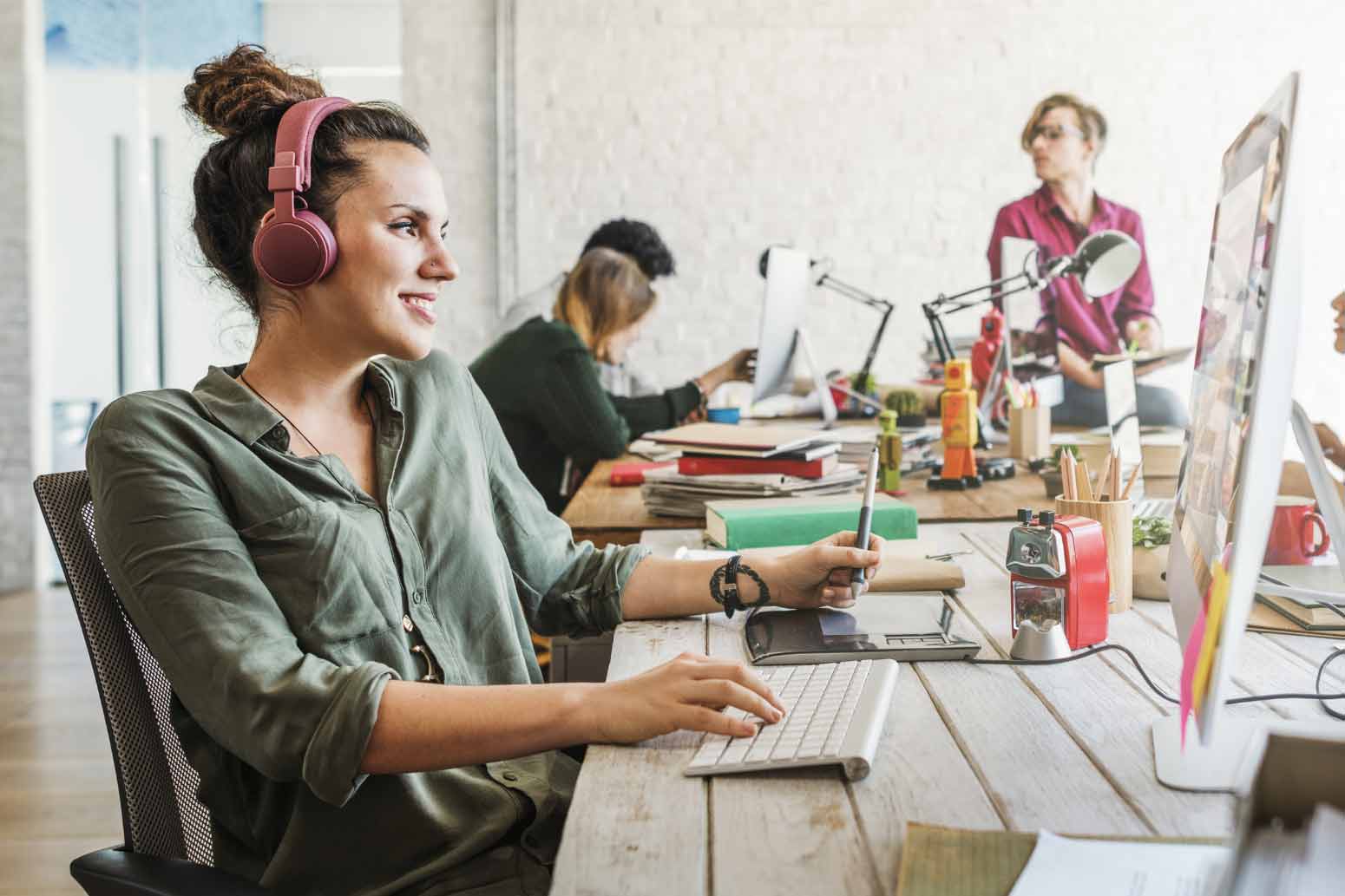 woman in an office smiles while working on a computer, having found a way for her calling and career to align