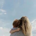 view from behind of mother holding a young boy and wondering "is motherhood my purpose?"
