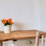 a simple wooden desk with a bouquet of flowers on top, symbolizing a home after you learn to simplify your life