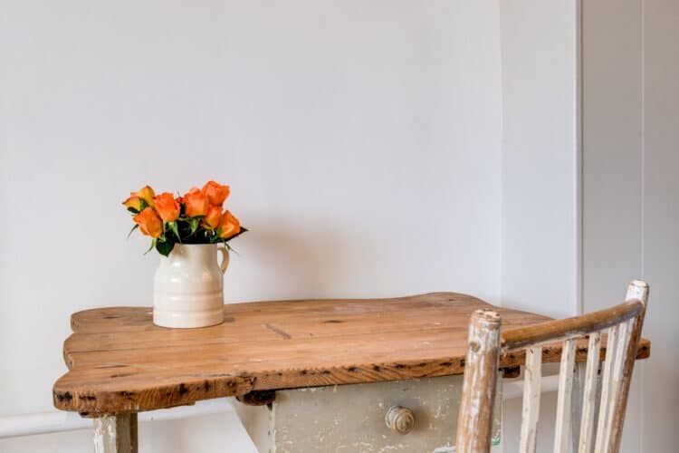 a simple wooden desk with a bouquet of flowers on top, symbolizing a home after you learn to simplify your life