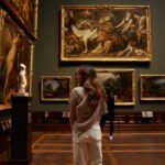 woman in a museum looking at masterpieces of art, even though she is one—a poiema