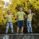 three little boys standing next to each other mussed up and happy at cousins camp
