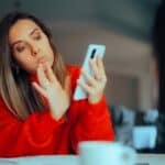 woman staring exasperatingly at her phone