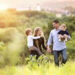 family walking through the grass, mom smiling at her spouse and navigating life as a wife before mother