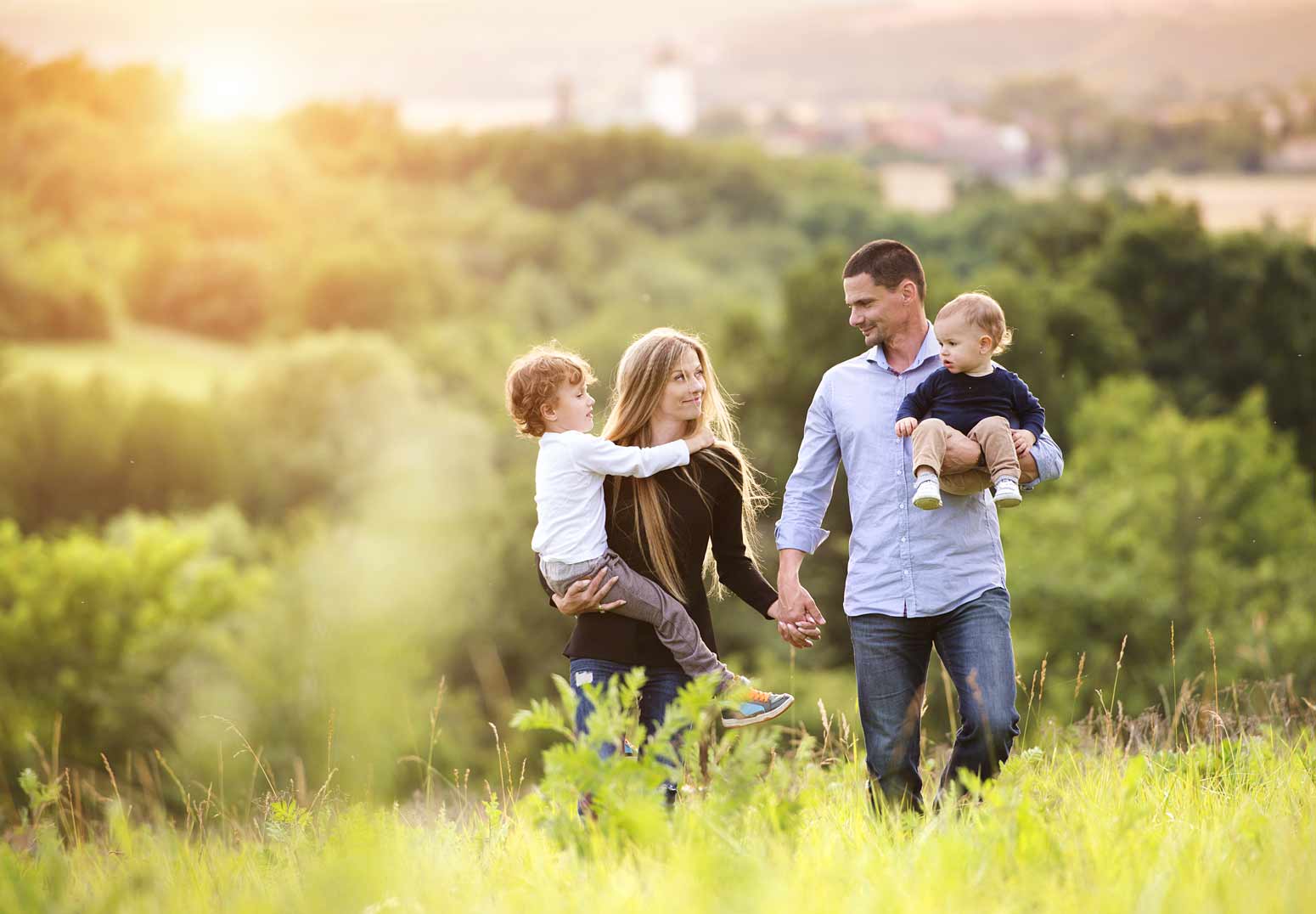 family walking through the grass, mom smiling at her spouse and navigating life as a wife before mother