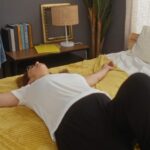 a woman sprawls out on her bed on her back, looking exhausted, illustrating perimenopause-related fatigue